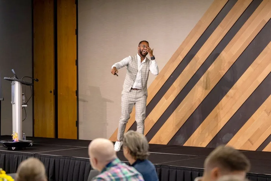 Darryl laughing on stage during a keynote
