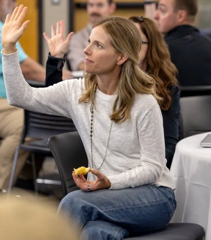 A staff member raises her hand during the keynote