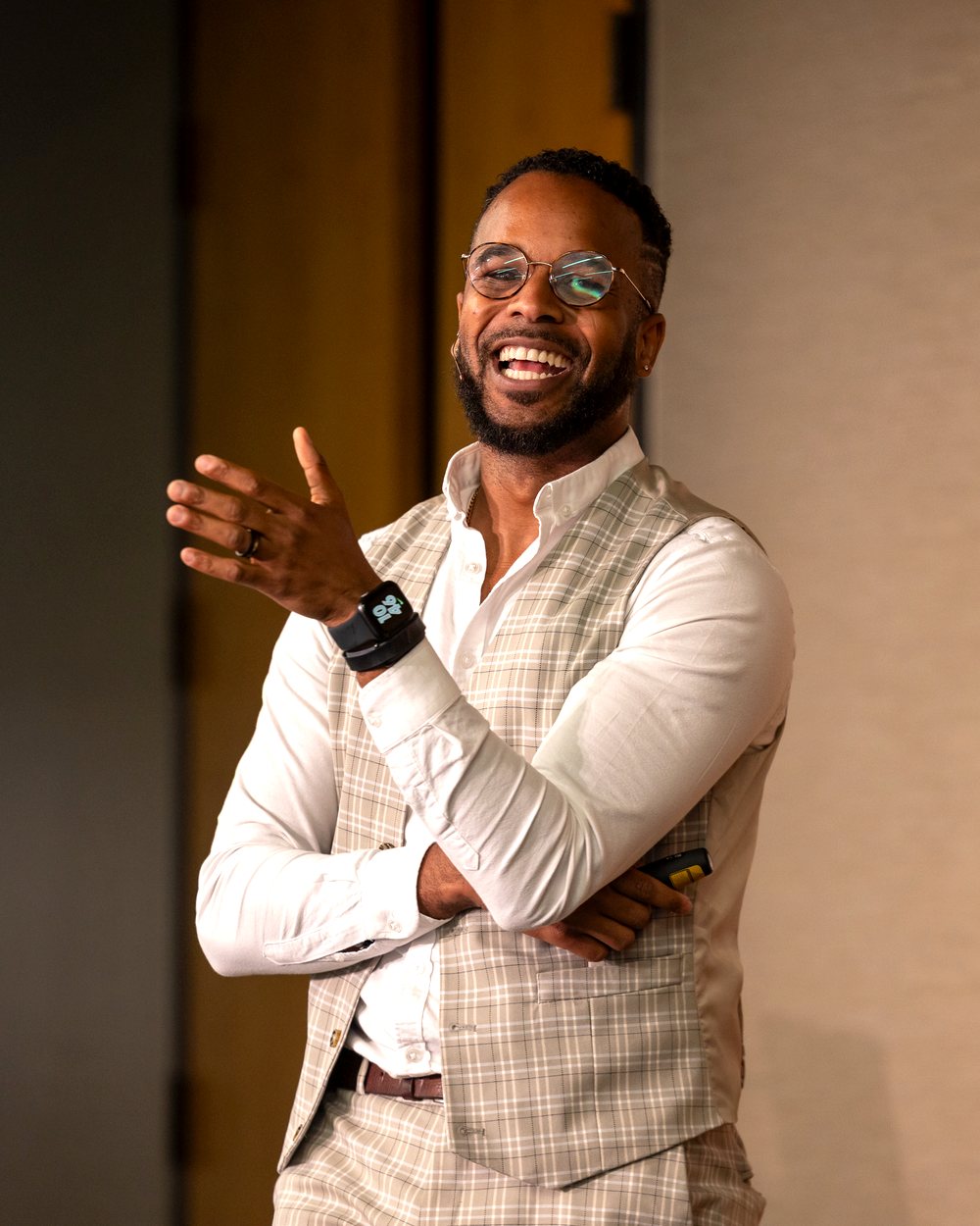 Darryl laughing on stage at a faculty and staff day