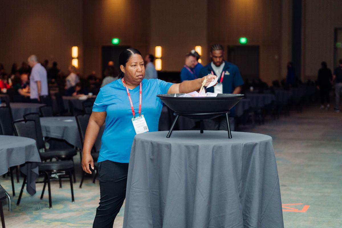Attendees putting their fear cards into the fire pit during a conference keynote.