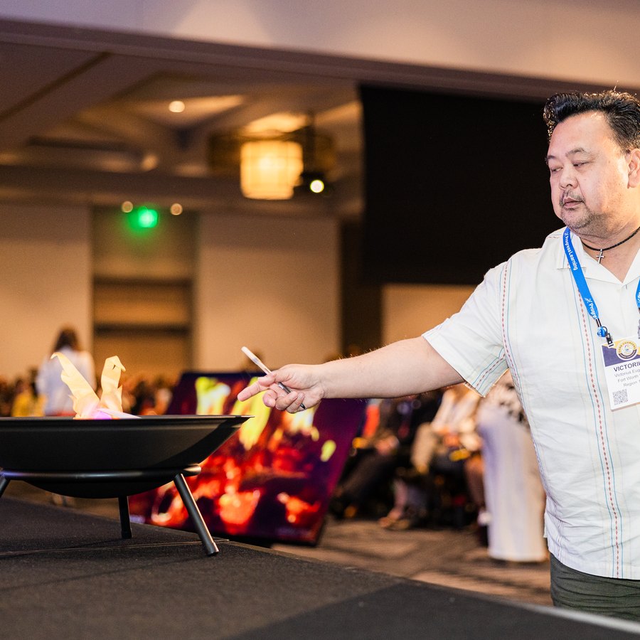 An educator drops his fear card into the fire pit during Darryl's keynote