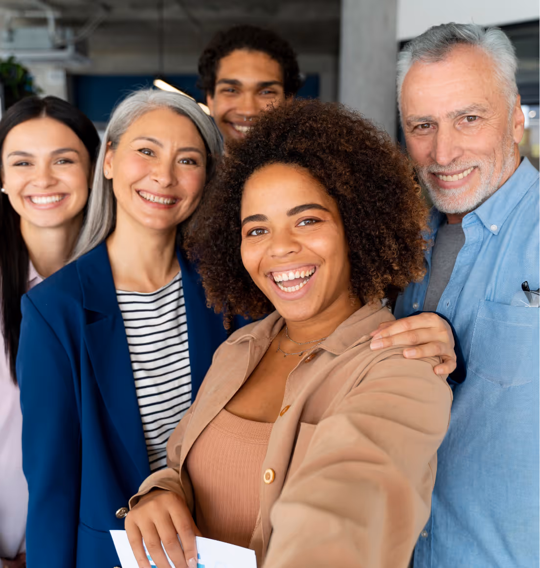 Group of diverse ACAM professionals smiling together for a selfie in a modern indoor setting, showcasing community and collaboration