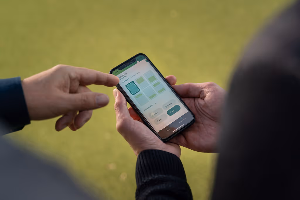 Smartphone mit LumosaTouch-App zur einfachen Steuerung der LED-Flutlichtanlage für Vereine.