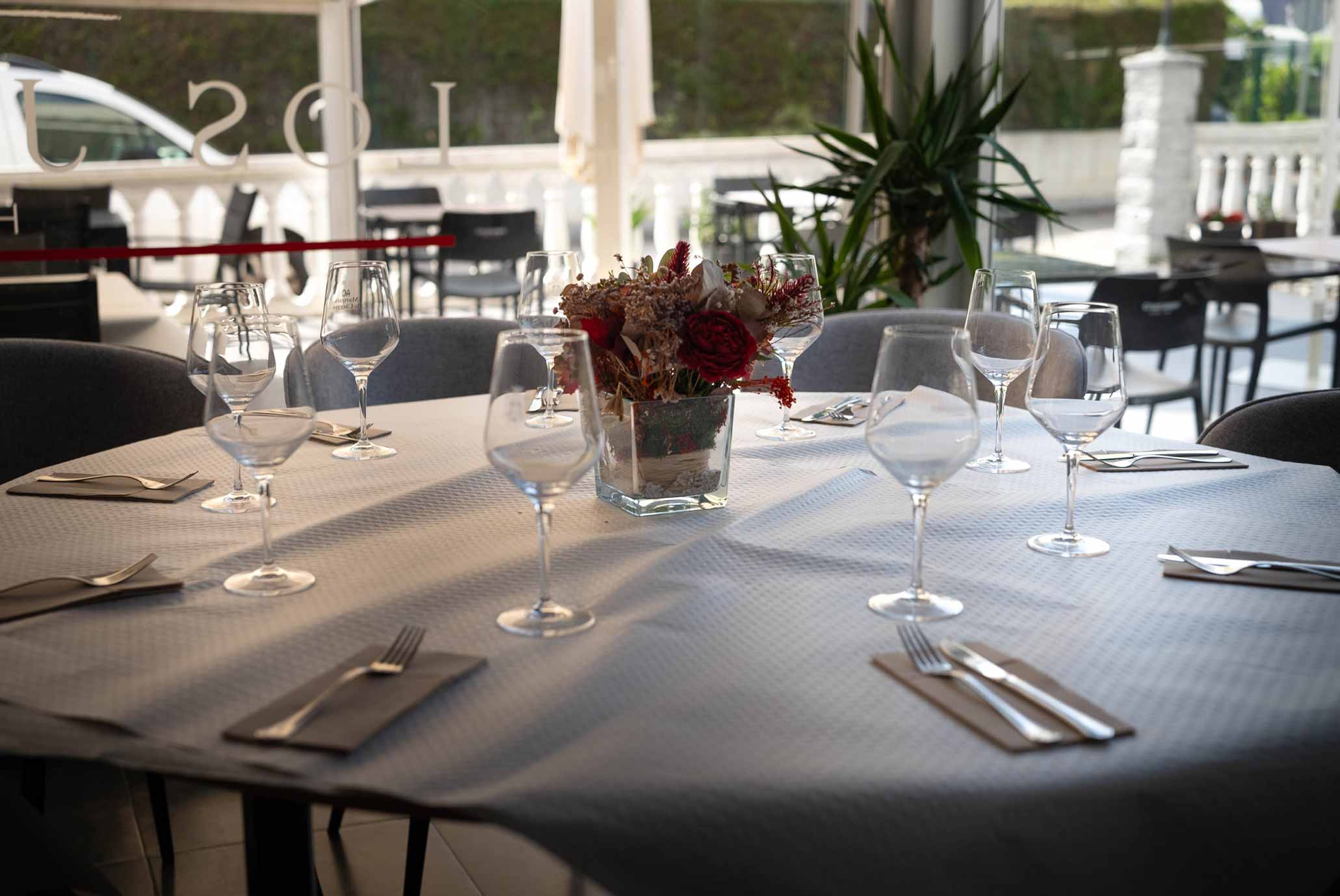 Mesa redonda preparada para una cena en el comedor de Hostería Los Jardines en Mortera
