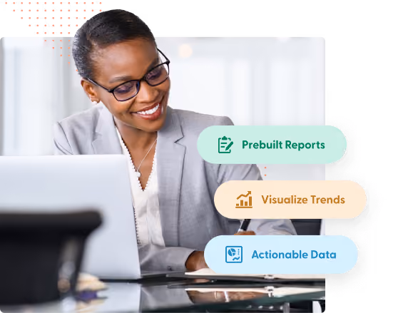 Smiling businesswoman in glasses and grey blazer working at a desk with laptop, with labels for Prebuilt Reports, Visualize Trends, and Actionable Data.