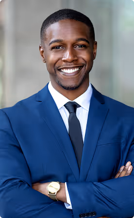 Confident man in blue suit with arms crossed smiling at the camera.