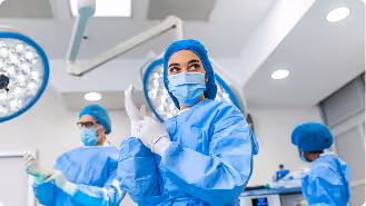 Medical team in blue surgical scrubs and masks preparing for surgery in an operating room.