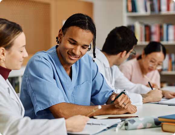 Group of medical students studying and writing notes together in a library or study room.