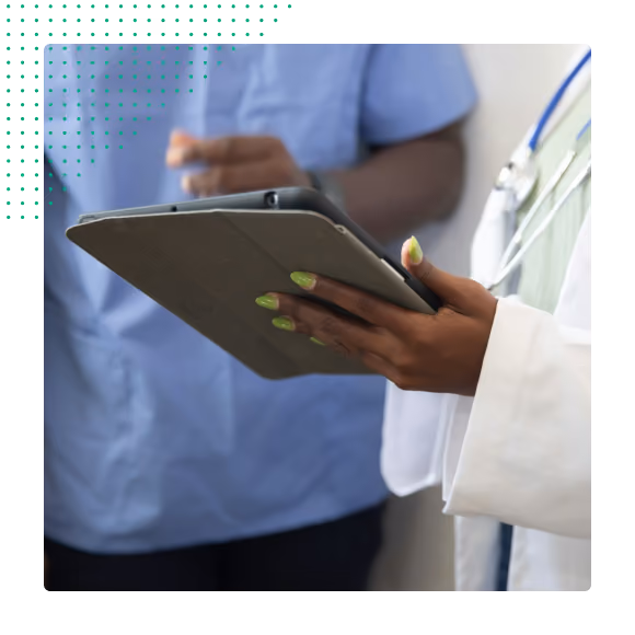 Hands of two medical professionals holding and using a tablet for patient information.