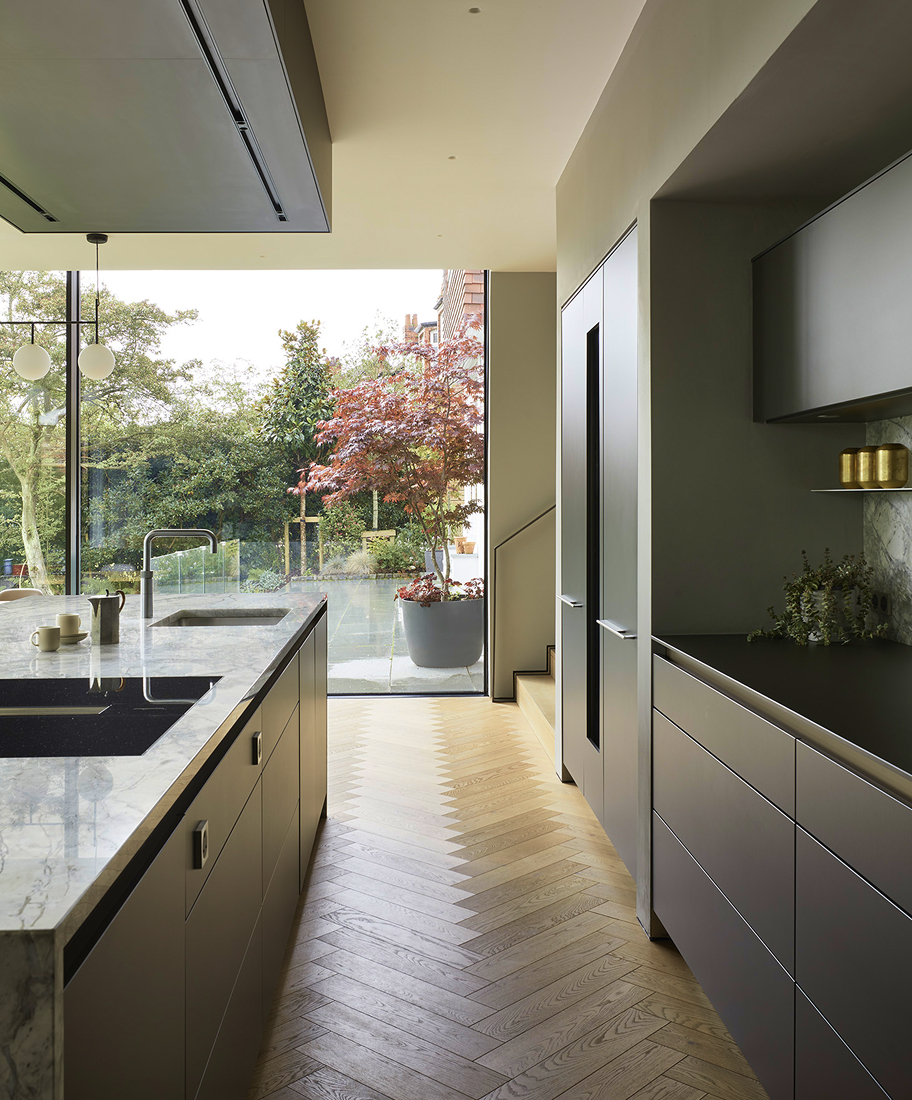 A modern kitchen with wooden flooring looking onto a garden