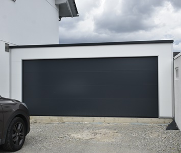 Einzelanbaugarage aus isolierten Sandwichpaneelen mit großem anthrazitfarbenem Sektionaltor, moderne Fertiggarage für Pkw