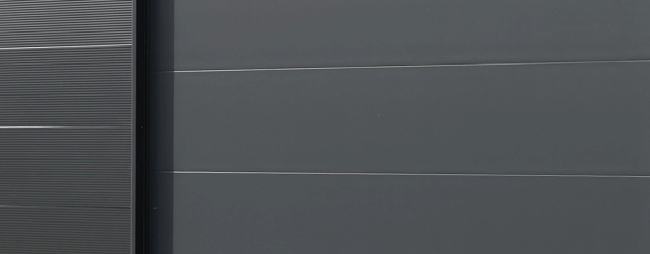 Moderne anthrazitfarbene Fertiggarage aus wärmegedämmten Sandwichpaneelen mit Flachdach – langlebig und in zeitlosem Design