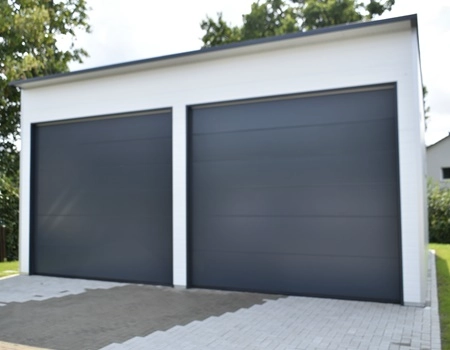 Großzügige Fertiggarage aus wärmegedämmten Sandwichpaneelen mit zwei großen Sektionaltoren in Sondermaßen – ideal für PKW, Wohnmobile oder Feuerwehrfahrzeuge