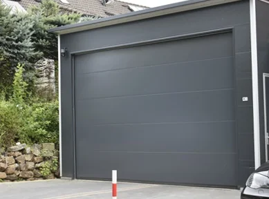 Großzügige Einzelgarage aus wärmedämmenden Sandwichpaneelen mit anthrazitfarbenem Sektionaltor in Überhöhe geeignet für Pkw und Transporter oder Werkstatt