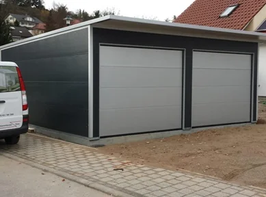 Moderne Doppelgarage aus wärmedämmenden Sandwichpaneelen in Grau mit zwei Sektionaltoren, ideal für Pkw und vielseitig nutzbar