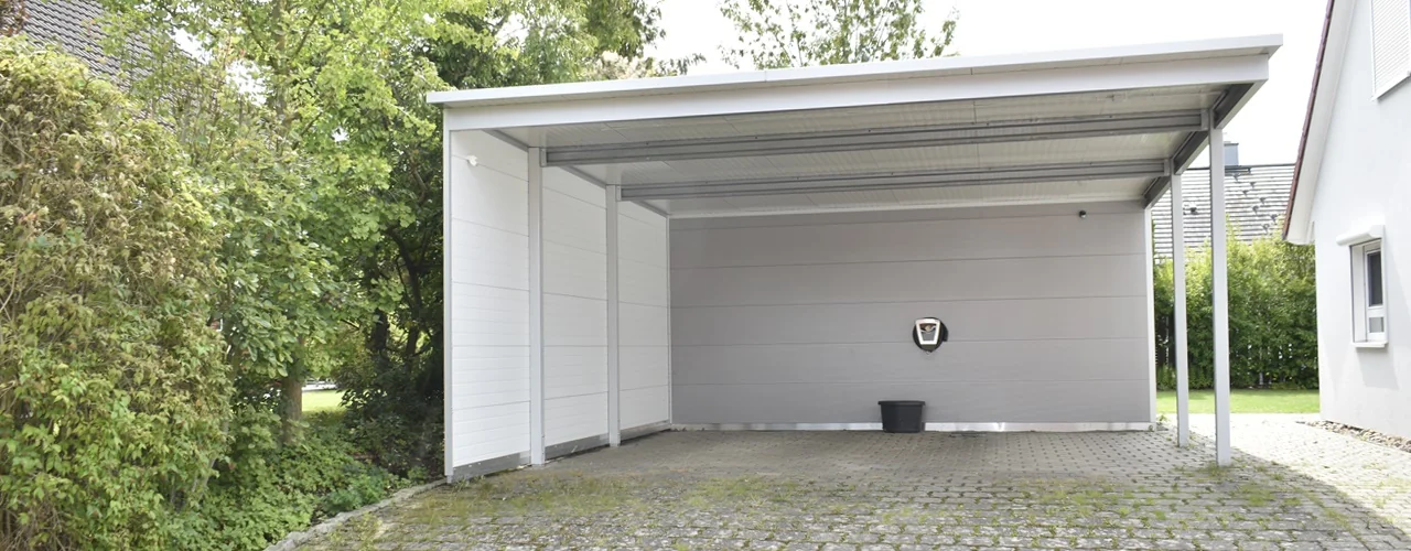 Carport in moderner Aluminiumoptik mit Sandwichpaneelen, Pultdach und integrierter Wallbox