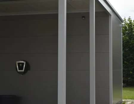 Detailaufnahme eines Carports mit Sandwichpaneelen, weißer Stütze und integrierter Wallbox