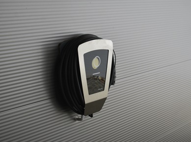 In einer Fertiggarage an der Sandwichpaneel-Wand montierte Wallbox-Ladestation für Elektroautos