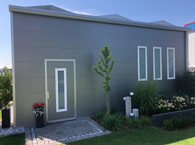 Moderne Doppelgarage aus grauen Sandwichpaneelen mit Tür und Fenstern