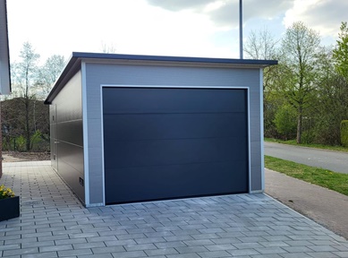 Freistehende Fertiggarage mit anthrazitfarbenem Sektionaltor aus Sandwichpaneelen