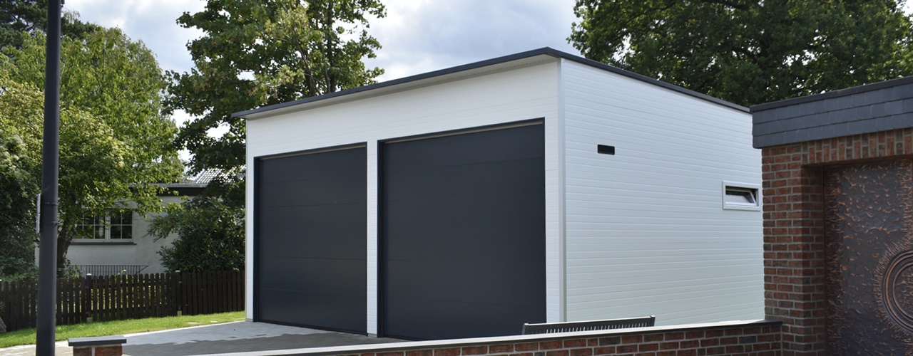 Moderne weiße Großraum-Doppelgarage mit zwei anthrazitfarbenen Sektionaltoren