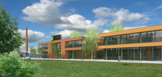 Modern two-story building with large glass windows, surrounded by trees and a green lawn under a partly cloudy blue sky.