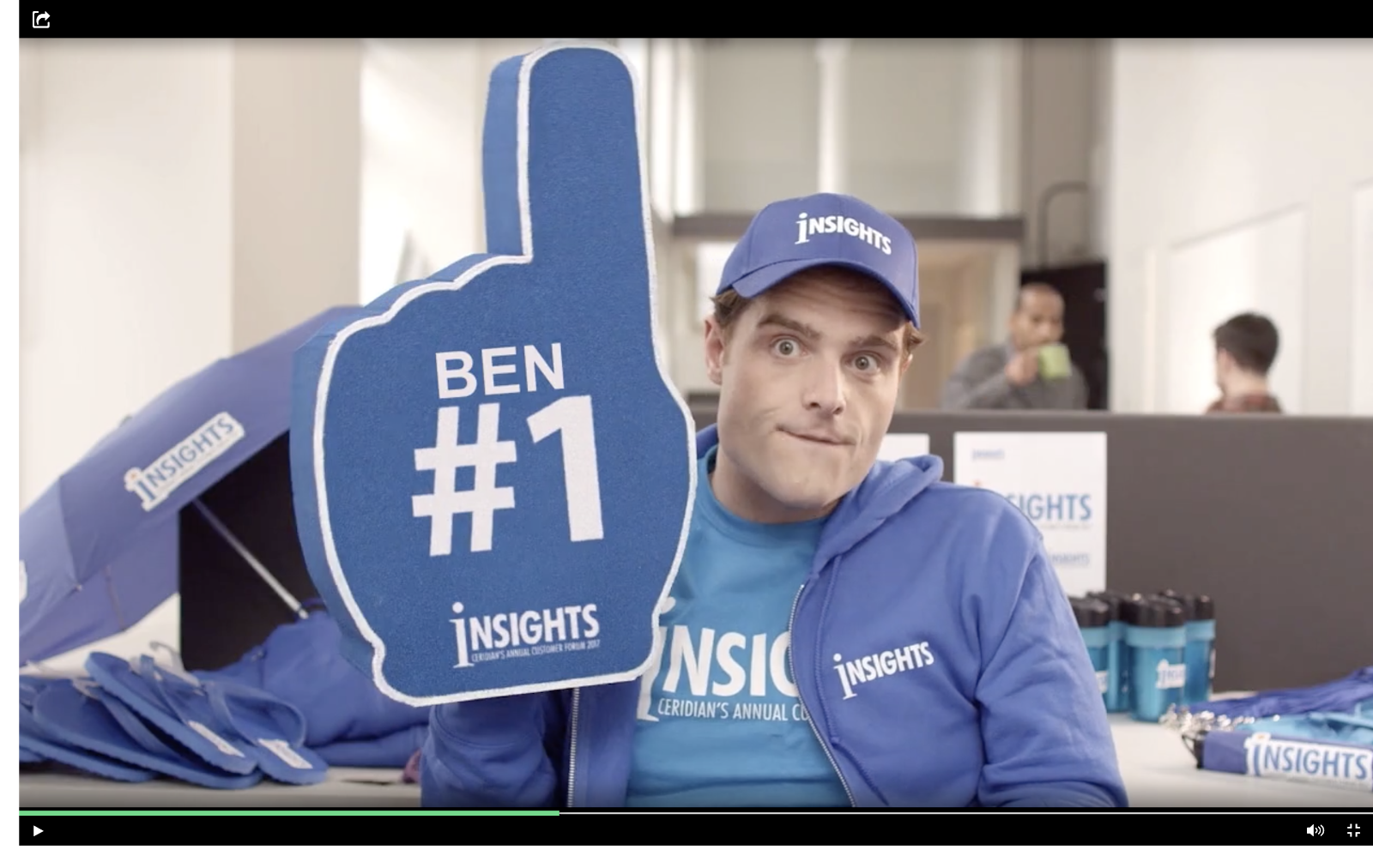 this is a screenshot image of a video clip still that shows a personalized marketing video. this is an example of marketing personalization. in this clip, a man is holding a foam finger with the user's name on it