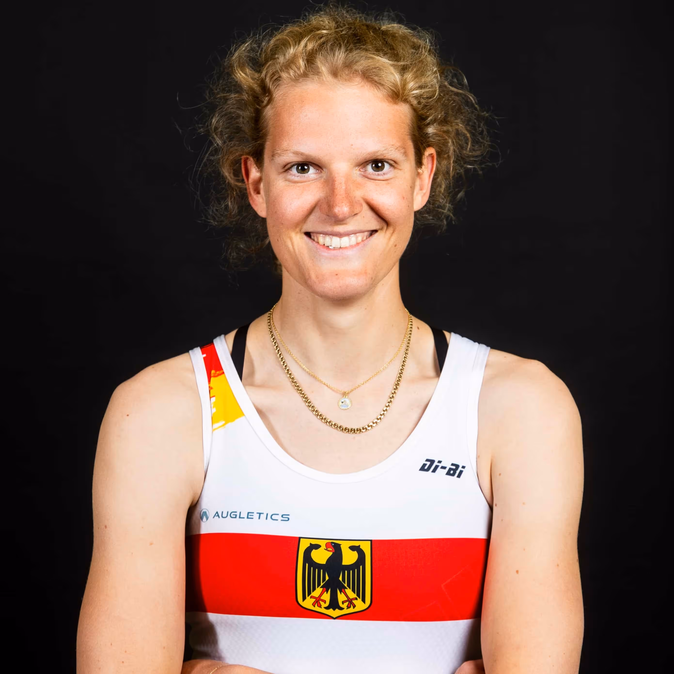 Porträt von Ricarda Heuser, Ruderin im deutschen Nationalteam, vor dunklem Hintergrund.