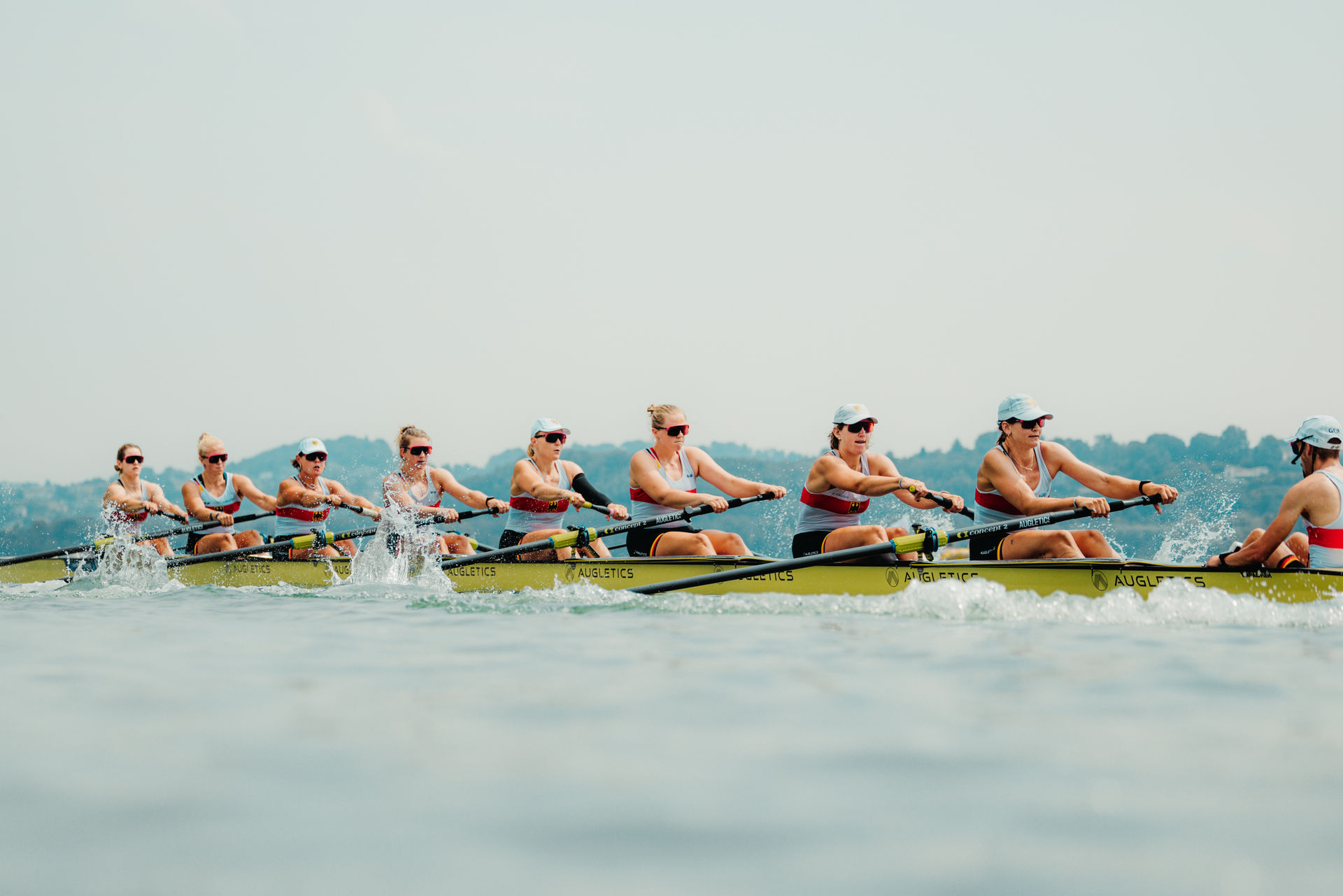 8 Ruderinnen und ein Steuermann sitzen in einem Ruderboot.