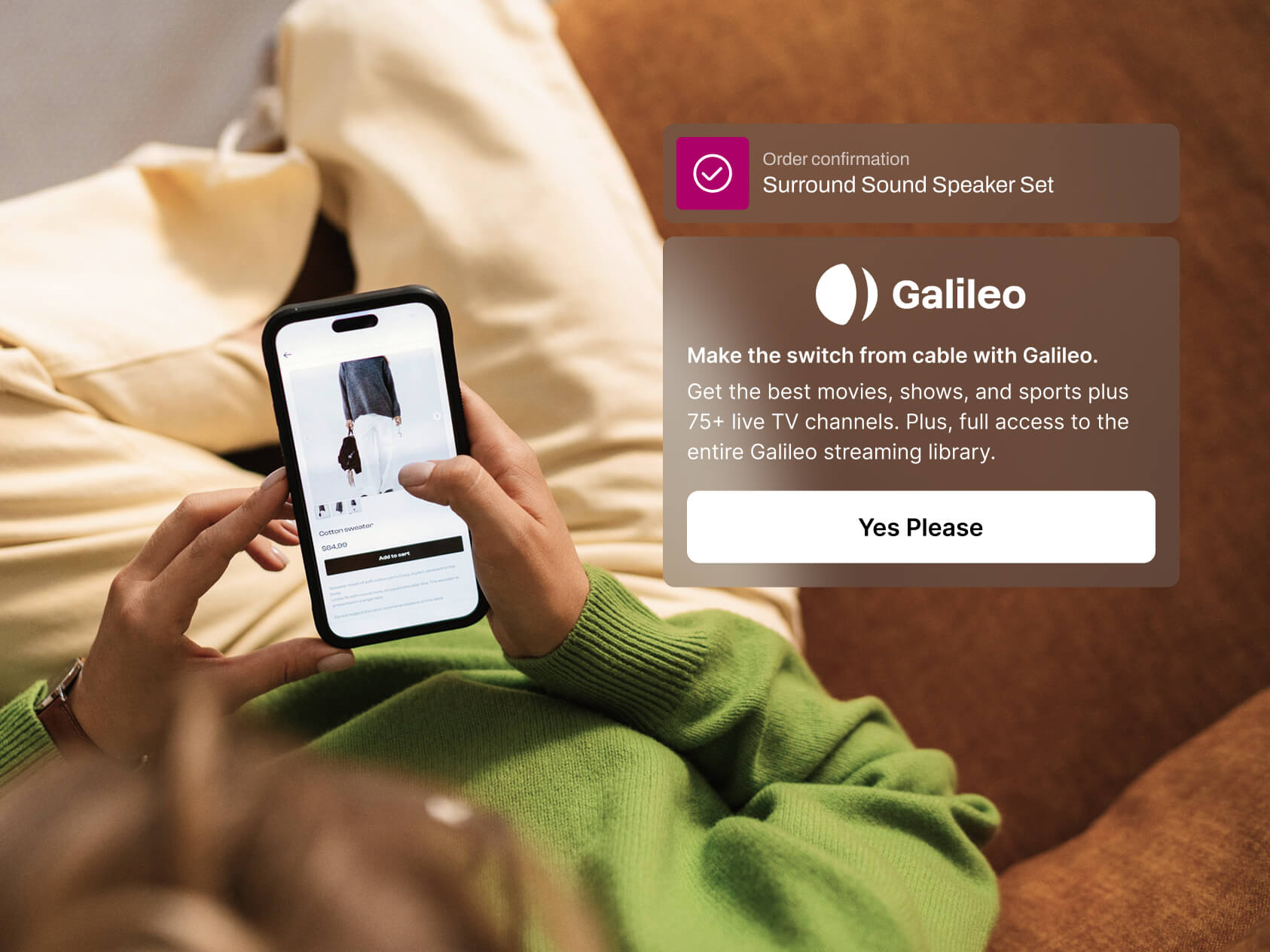 A person relaxes on a couch in cream pants and a green sweater, browsing an online clothing store on their phone. A UI overlay confirms an order for a surround sound speaker set and promotes switching to “Galileo,” a streaming service with a “Yes Please” button.