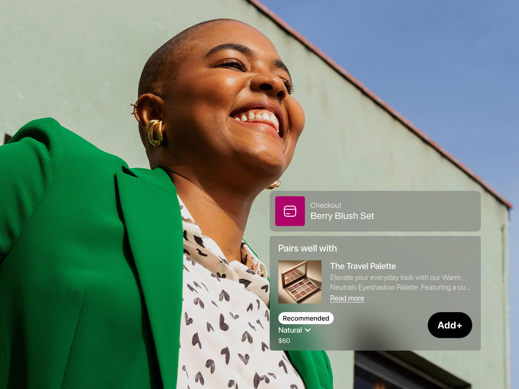 A stylish woman wearing a bright green blazer and printed blouse smiles broadly outdoors against a pastel green building. A digital overlay shows “Checkout – Berry Blush Set” and a recommended pairing with “The Travel Palette” eyeshadow set for $60. The overall tone suggests joyful, confident shopping enhanced by smart suggestions.