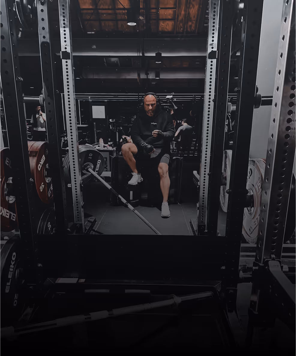 A man sitting on a bench in a gym.