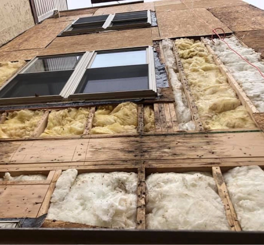Wall with exposed insulation and windows during home renovation process