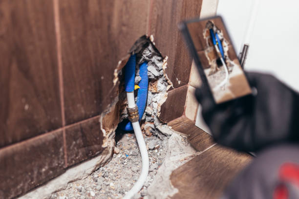 Blue plumbing pipe exposed through damaged wall during home renovation
