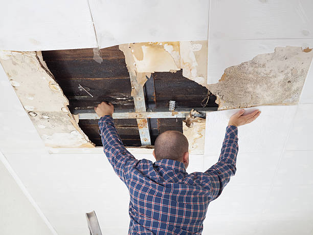 Person repairing damaged ceiling with metal support beam
