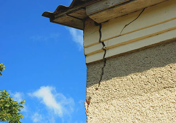 Large vertical crack running down side of stucco building exterior