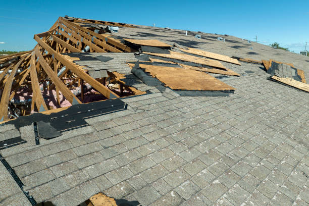 Damaged roof with exposed wooden trusses and missing shingles under blue sky