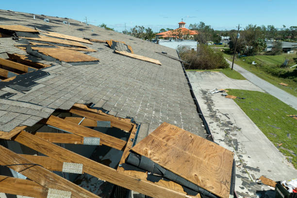 Damaged roof with missing shingles and exposed wood after hurricane or storm