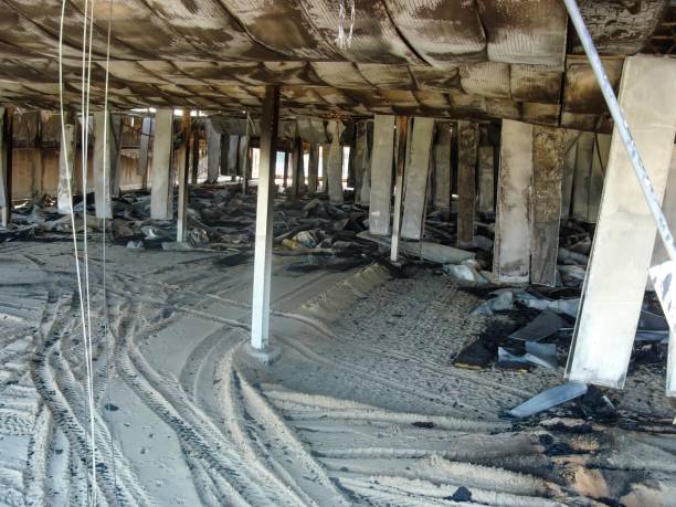 Aftermath of fire or disaster, damaged interior with debris and structural columns