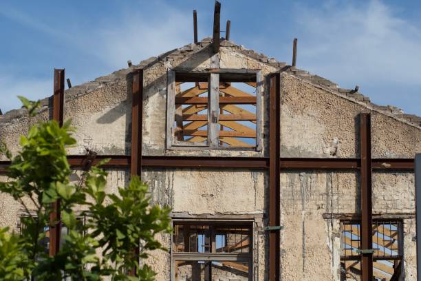 Abandoned concrete building with wooden beams and broken windows