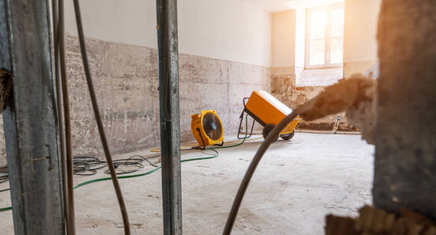 Construction site with yellow industrial fans and concrete walls