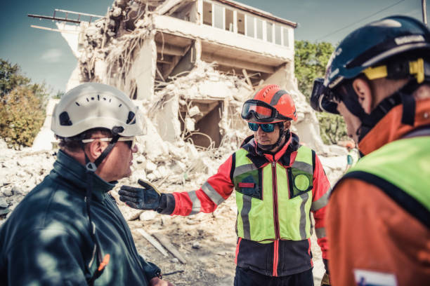 Rescue workers in safety gear assess damage near collapsed building