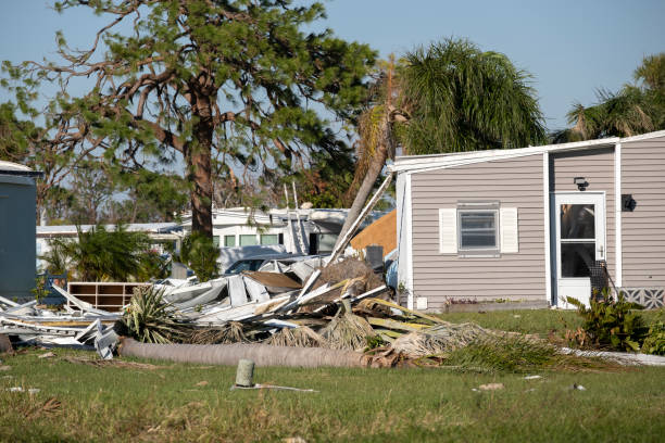 Hurricane damage with debris and broken mobile home in trailer park