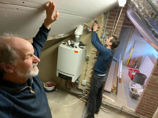 Two workers installing or repairing a water heater in a utility room