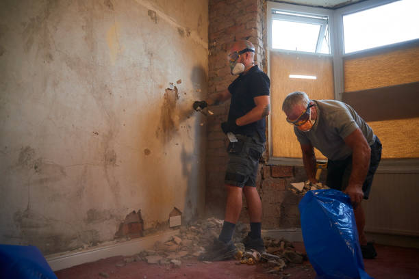 Two workers removing debris during home renovation project