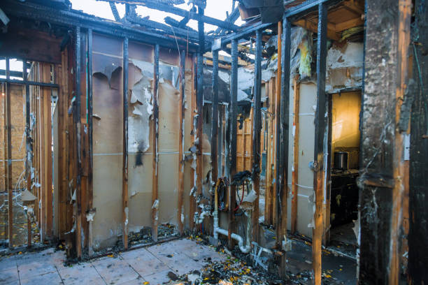 Burned and gutted interior of a building, exposed wooden frames and debris