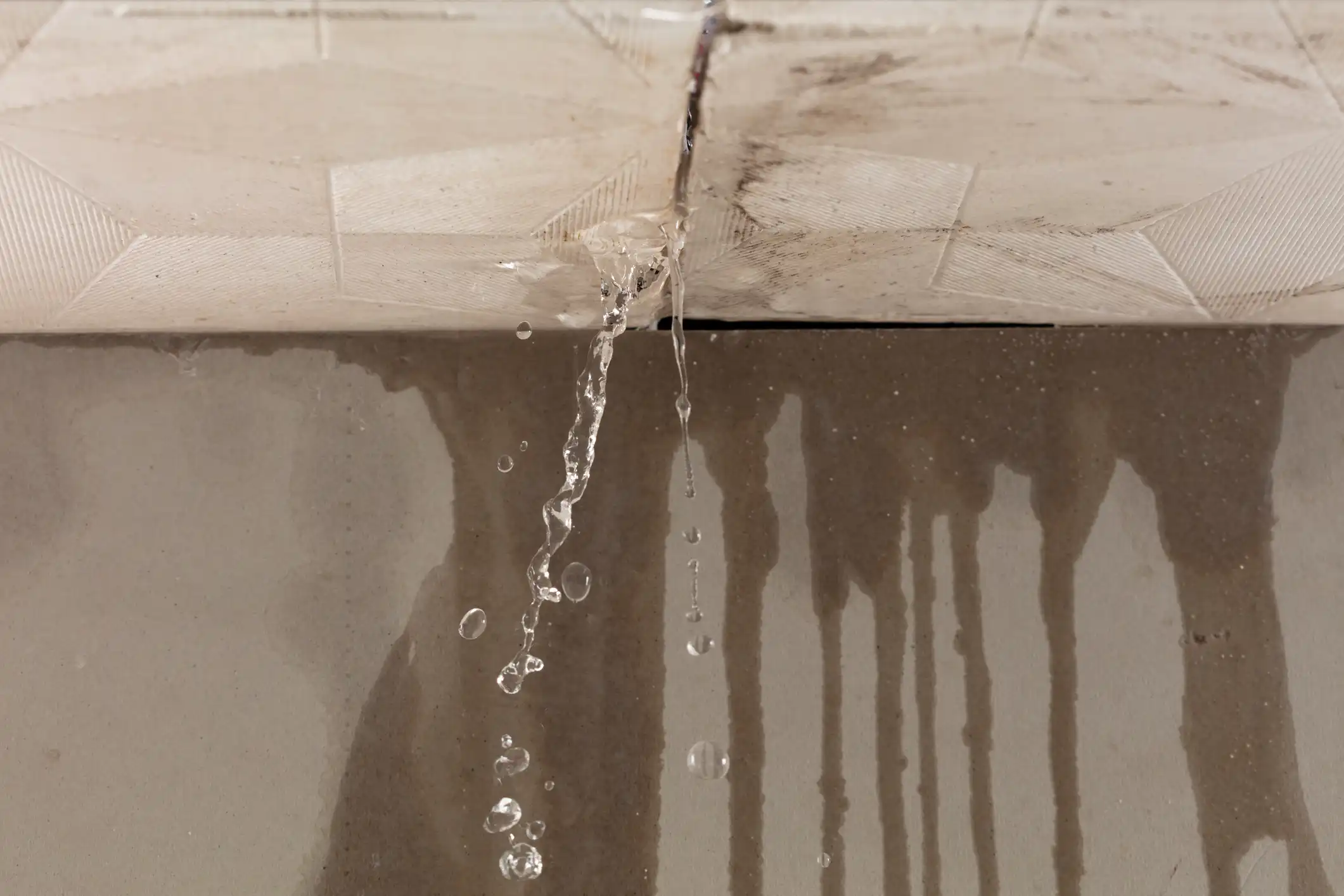 Broken ceiling with exposed blue water pipes and water damage