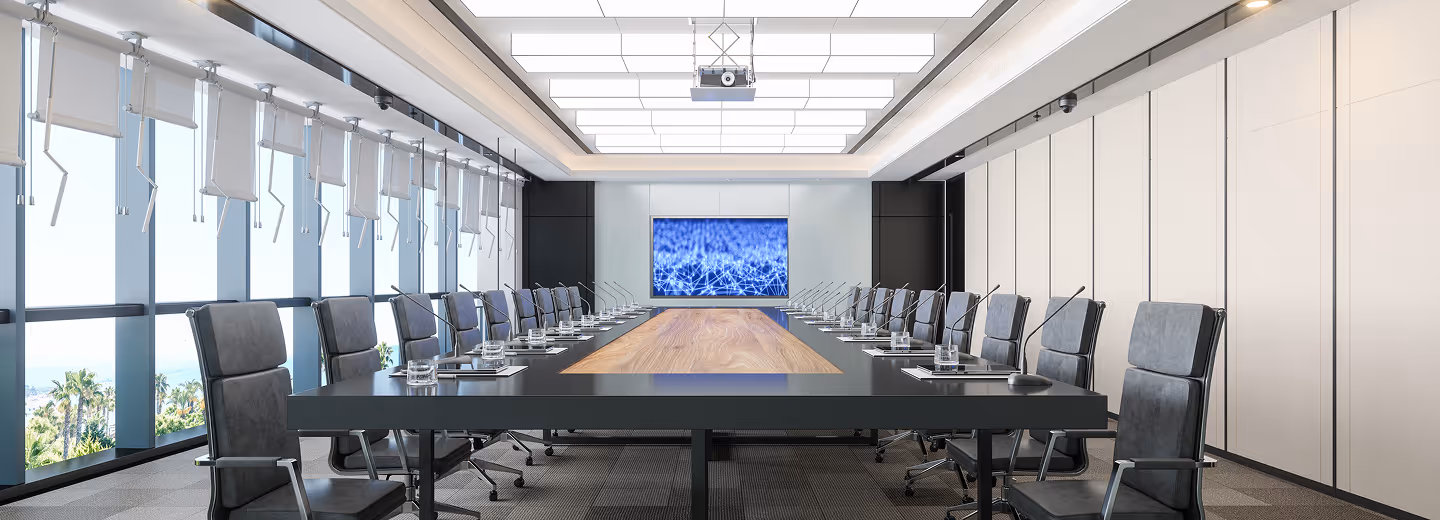 A hybrid coworking space boardroom with a long table and lots of chairs 