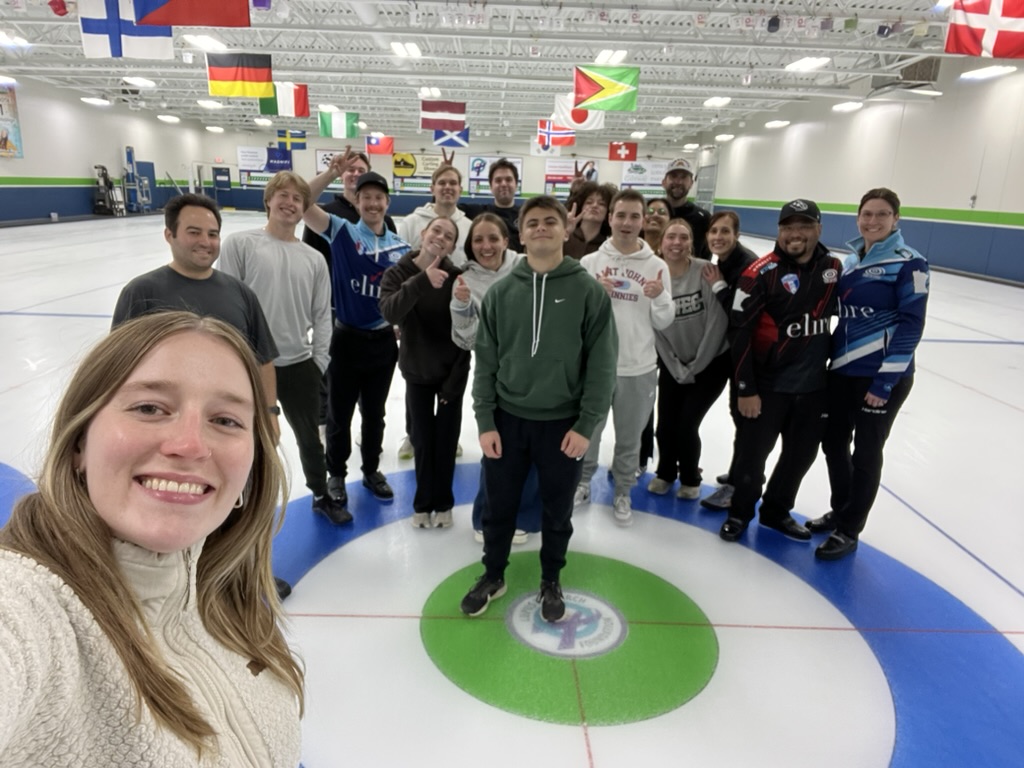 a group of people at a curling rink indoors