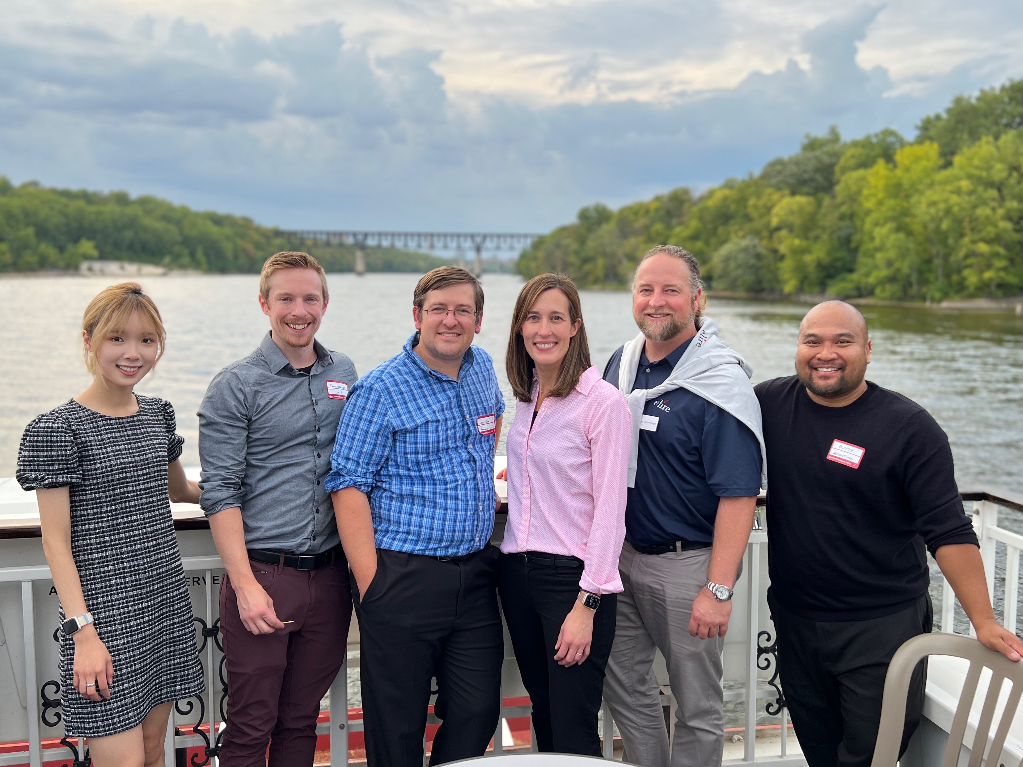 a diverse group of 6 people outside on a boat with name tags on